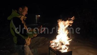 一个人在布拉齐尔附近用火取暖，在冬天他的手取暖。